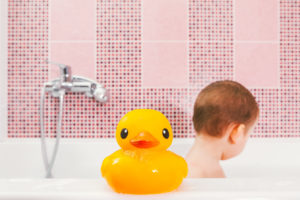Toddler having a bath with rubber ducky experiencing autistic inertia
